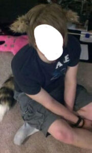 A teen posing with a tail and ears, ones that are not even authentic wolf colors.